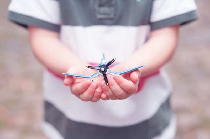 Child's hands holding a toy airplane